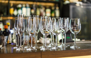 Empty white wine glasses on the table in the restaurant or bar. Table setting, close up. Glasses for alcohol. 