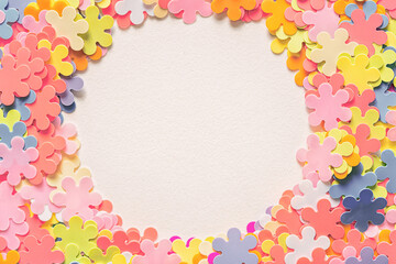 Top view of round frame with decoration artificial flowers on white background. Flat lay. Space for text.Postcard or greeting card.