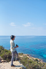 Fototapeta premium A young man holds his camera in front of a sea of beautiful blue colors