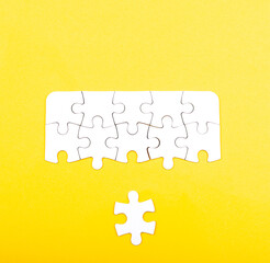 white jigsaw puzzle isolated on a yellow background