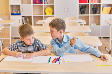 Happy school boys draw in the classroom. Creative little boys