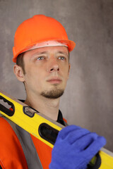 Portrait of a male engineer or builder with a construction level in hand. Vertical orientation