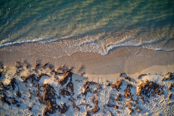 Drone field of view of water meeting beach in Mandurah, Western Australia.