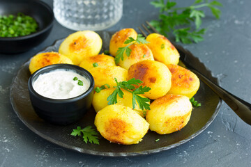 baked young potatoes with white sauce. View from above.