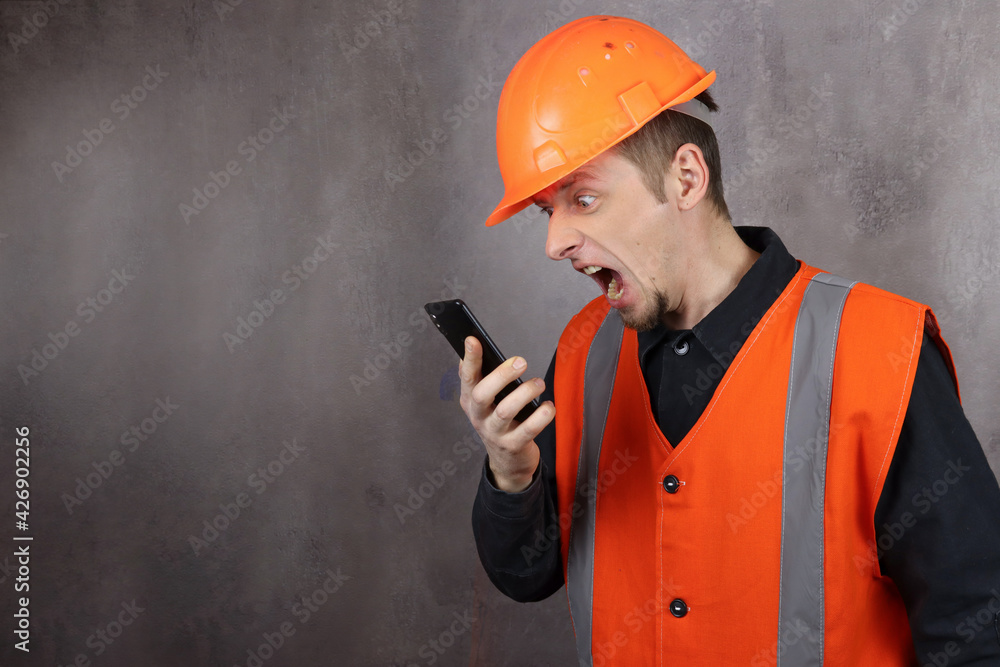 Wall mural angry man construction boss shouts on the phone at subordinates. space for text