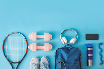 Set of sport equipment with backpack on color background