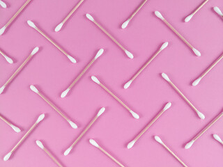 Pattern made from bamboo cotton buds on pink background.