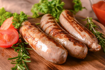 Board with delicious grilled sausages on wooden background, closeup
