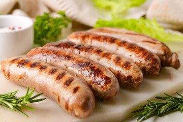 Board with delicious grilled sausages on light background, closeup