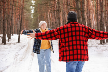 Happy mature couple in forest on winter day