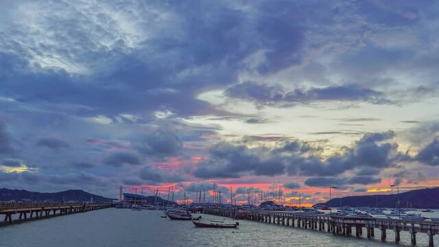 time lapse cloudy in stuning red sky above Chalong pier..Chalong marina is a center for intense boating activity in Phuket..4K UHD Stock video for tourism and nautical concepts.