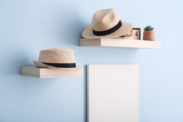 Shelves with stylish hats hanging on wall in room
