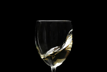Glass of wine with splash on dark background, closeup