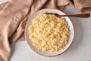 Plate with tasty couscous on light background