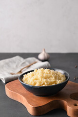 Bowl with tasty couscous on table