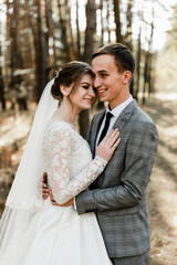the groom hugs the bride with a smile on his face. lovely wedding day of cute couple. rustic wedding. bride blonde. international wedding. European couple.