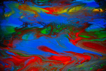 Texture in the style of fluid art. Abstract background with swirling paint effect. Liquid acrylic paint background. Red, green, yellow and blue colors.