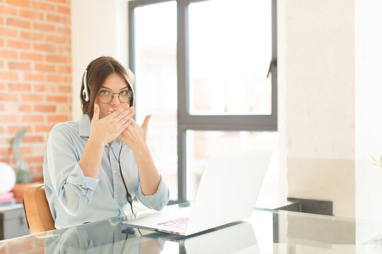 pretty telemarketer covering mouth with hands with a shocked, surprised expression, keeping a secret or saying oops