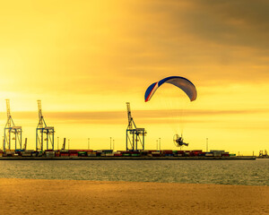 paragliding flight over the Baltic beach at sunset