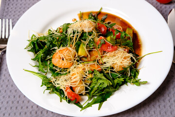 caesar salad with prawns on a white plate