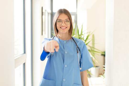 Pretty Nurse Pointing At Camera With A Satisfied, Confident, Friendly Smile, Choosing You