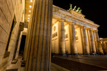 Brandenburger Gate from the side in bright golden light at night in the middle of Berlin