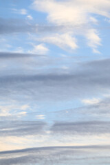 Obraz premium Streaky pastel clouds in early evening, shades of blue, gray, and white, as a nature background 