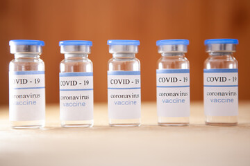 Vaccination covid-19 ampoules on brown background, Coronavirus vaccine