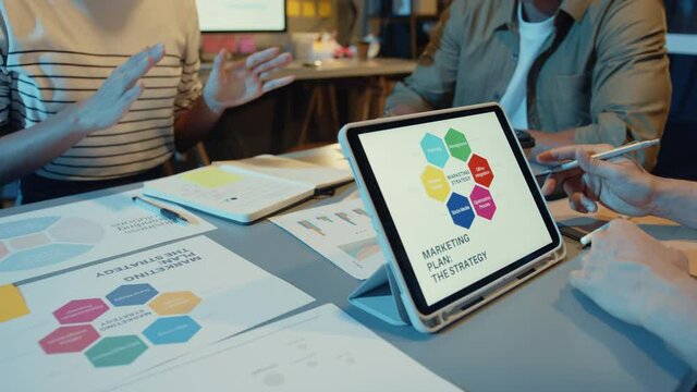 Asia businesspeople meeting plan analysis statistics brainstorm and header of team hold tablet point graph chart and employee take note in modern home office night. Finance strategy success concept.