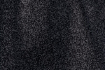 Black textured smooth leather surface background, medium grain