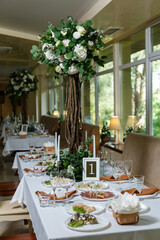 Newlyweds table setting decorated in rustic style. Wedding decor with flowers, candles, succulents, greenery and wooden elements. Nature theme in decoration