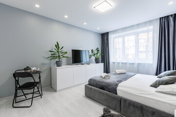 Interior photography, bedroom, in a small studio apartment, with a large bed and white walls