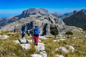 Fototapeta premium Wanderurlaub in Mallorca im Tramuntana Gebirge - Gruppe auf dem Grat über Soller mit Blick Richtung Puig Major und Stausee Cuber