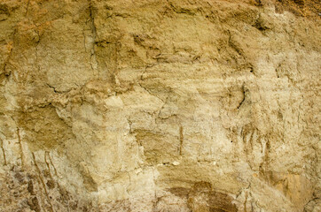 Natural background - vertical wall of sand in sand pit.