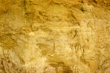 Natural background - vertical wall of sand in sand pit.