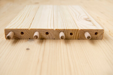 Assembly parts made from pine wood. Bars have holes. Сonstruction fasteners are inserted into...