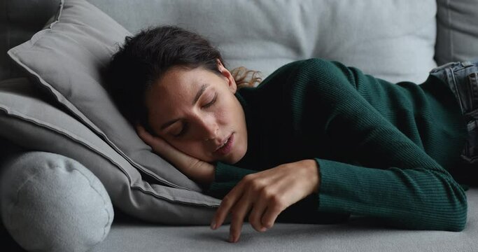 Bored disinterested young caucasian woman lying on cozy couch, suffering from loneliness alone at home, feeling unmotivated unproductive indoors, waste of time, lazy inactive weekend pastime concept.