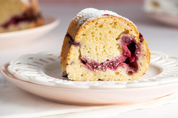 Raspberry Breakfast Bundt Cake slice with cake on pink plate in the background. Light and bright style.