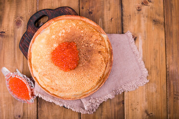 Shrovetide Maslenitsa Week festival meal. Stack of russian pancakes with red caviar. Rustic style, free space for text, Top view