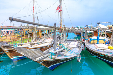 Fototapeta na wymiar Al Khor, Qatar - February 23, 2019: fishing boats or traditional wooden dhows at harbor of Al Khor resort near Doha famous for its new Fish Market. Qatar, Middle East, Arabian Peninsula.