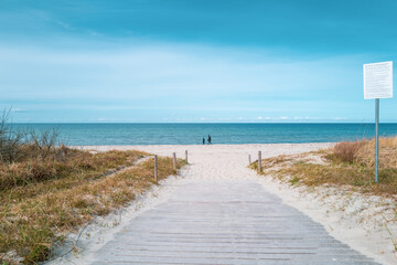 Fototapeta na wymiar path leads to the blue water of the Baltic Sea and the sky is blue