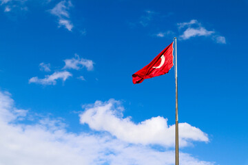 the turkish flag waving in the wind against the blue sky