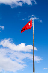 the turkish flag waving in the wind against the blue sky