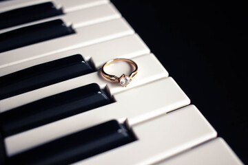 Engagement ring on a piano with dark background
