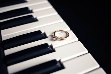 Engagement ring on a piano with dark background