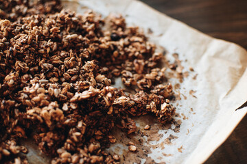 Homemade granola with nuts and seeds on baking sheet with ingredients. Granola for healthy breakfast.