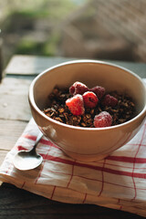 Delicious and healthy breakfast with raspberries. Morning aesthetics and beautiful layout on a wooden table. Granola for healthy breakfast.