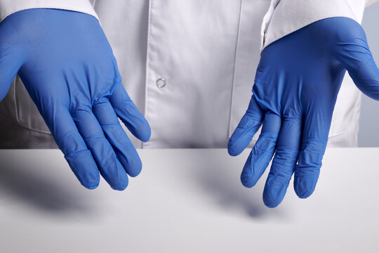 Doctor presents blue gloves on hands. Clean hands inside nitrile surgical gloves. Professional medical safety and hygiene for surgery and medical executions. Concept photo for healthcare agitation.