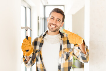 handyman smiling confidently pointing to own broad smile, positive, relaxed, satisfied attitude