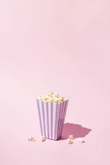 Fotobehang Pop corn striped box for a movie night. Retro scene in pastel colors. © Elizia Jovanovic